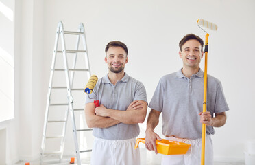 Portrait of a two happy Caucasian men, working as painters, are depicted during a home renovation....