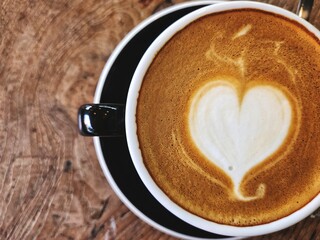 Heart coffee latte art milk foam on wood table background
