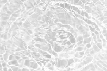 White water with ripples on the surface. Defocus blurred transparent white colored clear calm water surface texture with splashes and bubbles. Water waves with shining pattern texture background.
