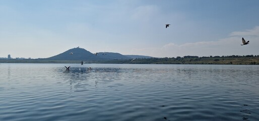 lake Most under the peak Hněvín with castle and lookout, artificial post mining revitalised coal mine small power plant around 