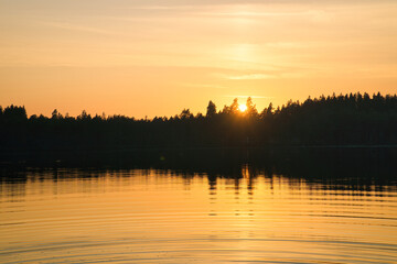 Obraz premium Sunset with warm colors on a Swedish lake in Smalland. Romantic evening atmosphere