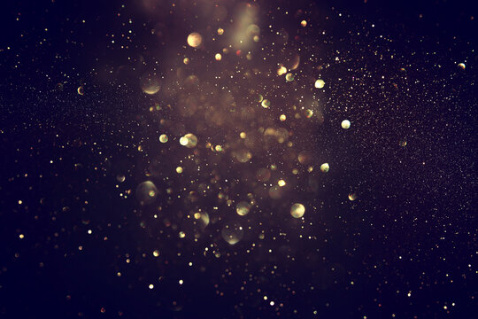 blackground of abstract glitter lights. blue, gold and black. de focused