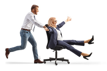 Man pushing a businesswoman seated in an office chair