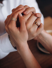 The newlyweds hands were intertwined, displaying their wedding rings , symbolising unity and love