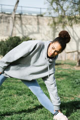 Fototapeta premium Woman Stretching Outdoors in a Park During Workout