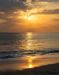 Golden sunset over a tranquil ocean with gentle waves and a sandy beach. Martha's Vineyard