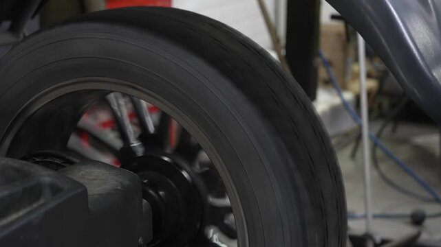 Mechanic balancing a wheel in a workshop. 
