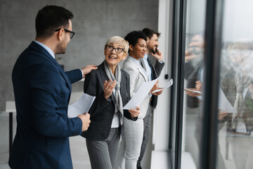 Group of business people standing near windows at office room