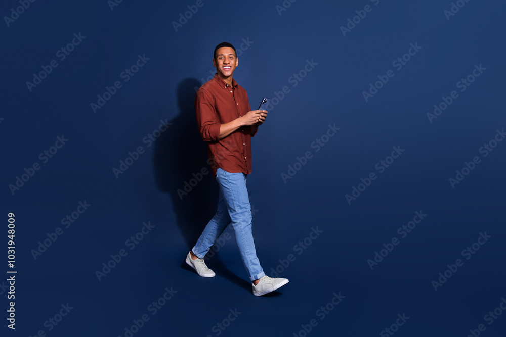 Canvas Prints Full length photo of cheerful positive guy dressed brown shirt typing sms modern device emtpy space isolated blue color background