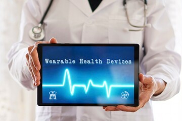 wearable health devices concept with a female doctor showing a tablet with a medical app