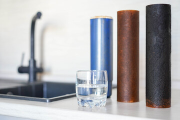 Dirty used drinking water filters and glass of water, pure water concept