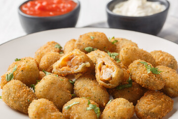 Seafood appetizer breaded mussels served with mayonnaise and ketchup close-up in a plate on a...