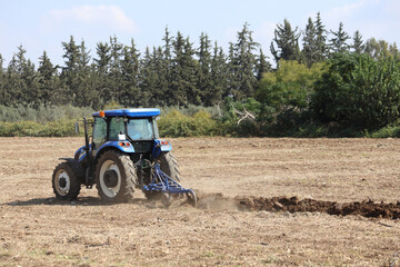 Obraz premium farmer plowing field in autumn