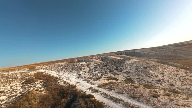 The camera flies low over the chalk mountains, there is no one around and a beautiful view from above.