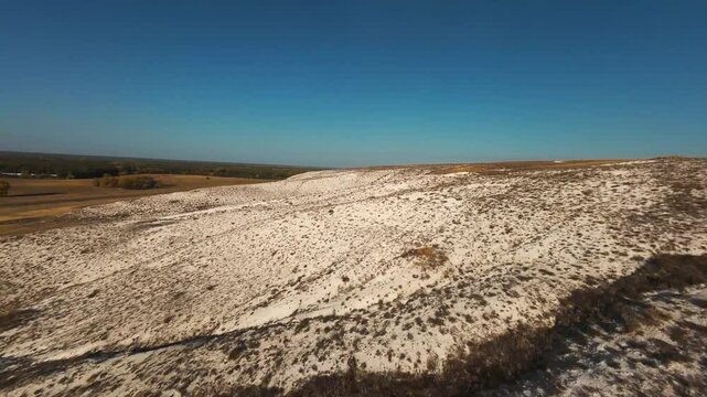 The camera flies low over the chalk mountains, there is no one around and a beautiful view from above.