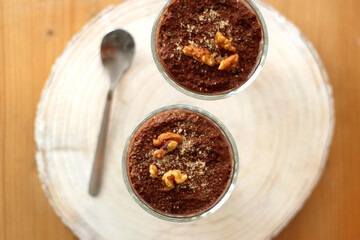 Two bowls of chia seed, chocolate and orange pudding. Healthy snack, wooden background. Top view.