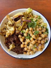 A plate of healthy meal served with slow cook beef cheek, roasted cauliflowers and chickpea salad 