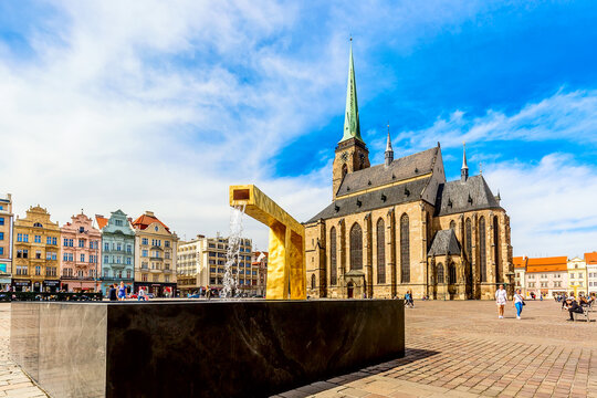 St. Bartholomew's Cathedral in the main square of Plzen with a fountain on the foreground against blue sky and clouds sunny day. Czech Republic, Pilsen. Famous landmark in Czech Republic, Bohemia.