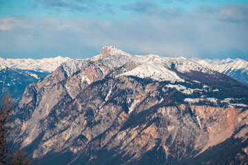 Obraz premium Breathtaking panoramic view of a snow-capped mountain peak Dobratsch seen from Karawanks, Carinthia, Austria. Twilight atmosphere. Natural beauty and peaceful tranquility in Austrian Alps in winter