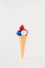 Ice cream cone with Christmas tree decorations on a white background. Minimal Christmas holiday greeting card idea.