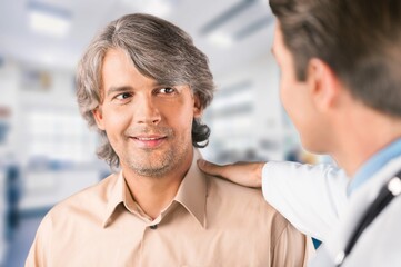 Young smart doctor with patient consulting in hospital.