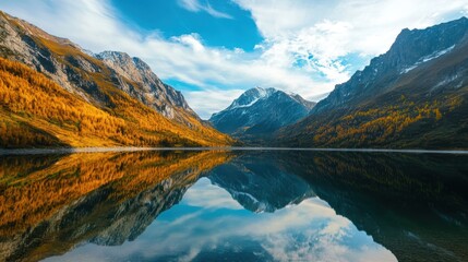 Fototapeta premium Mountain lake with sky reflection and autumn foliage.