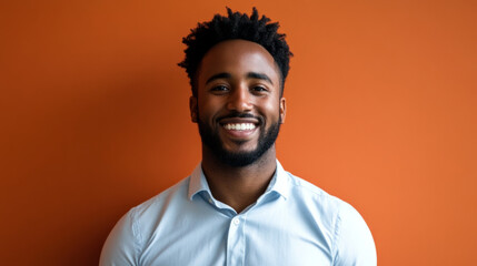 Fototapeta premium A confident individual smiling warmly in front of a vibrant orange background at a casual gathering