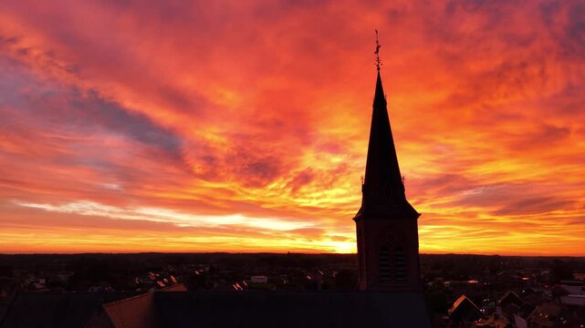 Stunning sunset view over a church steeple in the countryside at dusk