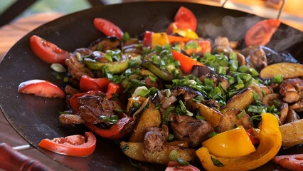 Delicious saj with roasted meat and vegetables on table Sizzling meat perfectly grilled with fresh vegetables Ideal for showcasing appetizing meals, with focus on succulent meat and vibrant vegetables