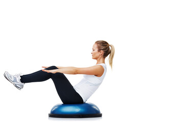She loves working out and staying fit. A young woman balancing on a bosu-ball.