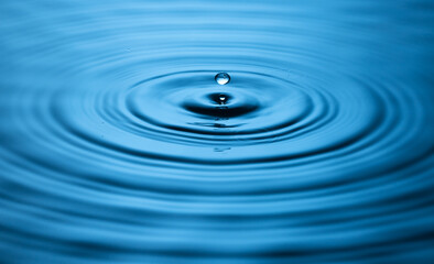 Blue Water drop falling, macro splash. Natural background