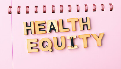 Obraz premium Message health equity with wooden letters on notebook in pink isolated with white highlights, png