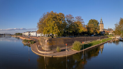 Defense wall seen from above against blue vibrant colourful sky with quay visible of river IJssel...