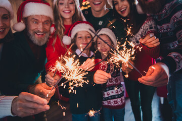 Cropped photo of big full family hold bengal light celebrate christmas festive time apartment indoors