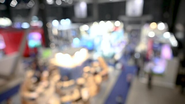 Intentionally blurred footage of people visiting pavilions and booths during a business trade fair 