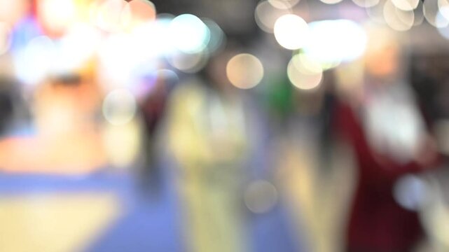 Intentionally blurred footage of people visiting pavilions and booths during a business trade fair 