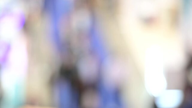 Intentionally blurred footage of people visiting pavilions and booths during a business trade fair 