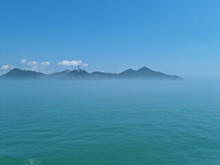 It is a foggy sea and island.