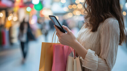 Shopping enthusiast checking mobile phone while holding colorful shopping bags in vibrant market. atmosphere is lively and filled with soft bokeh lights, creating cheerful mood