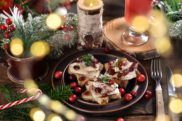 Star shaped canapes with herring fillets and cranberries on Christmas table in rustic style