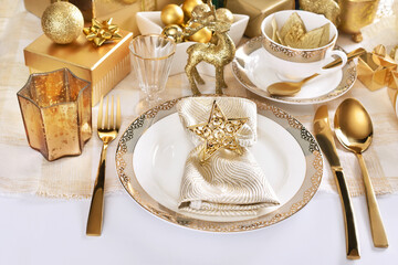 Glamour style Christmas table setting in white and gold colors