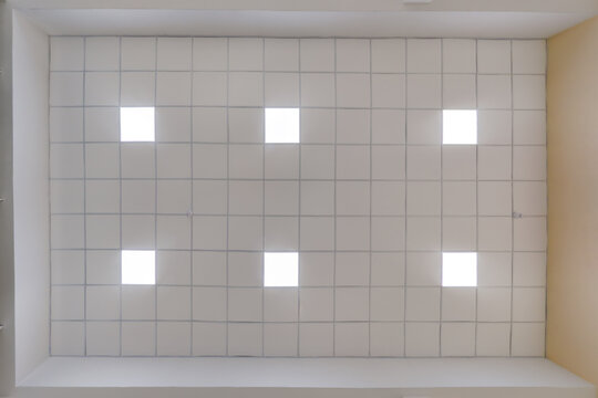 cassette stretched or suspended ceiling with square halogen spots lamps and drywall construction in empty room in house or office. Looking up view