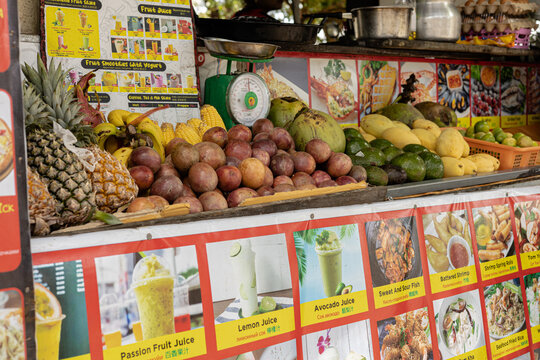 Street food stall selling fruit juice and smoothies from fresh fruit, Thai street food with photos and names of the dishes.