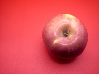 An apple on the red background. Organic, sweet, and fresh fruit
