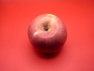 An apple on the center of red background. The sweetness of red apple. Organic fruit