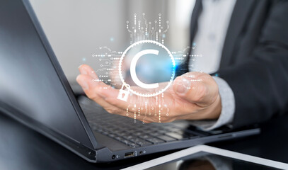 Businessman with copyright technology symbol on virtual screen for author rights and patent intellectual property