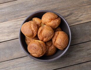 Broa, typical brazilian corn flour bread in a bowl over wooden table