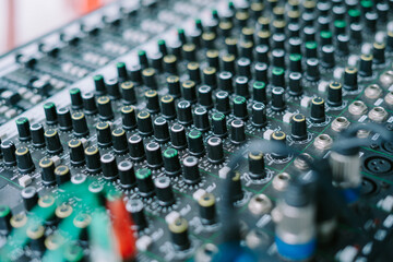 Obraz premium A close-up shot of an audio mixer with various knobs, faders, and buttons