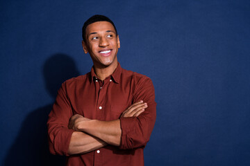 Photo of dreamy cool guy dressed brown shirt arms crossed looking emtpy space isolated blue color...