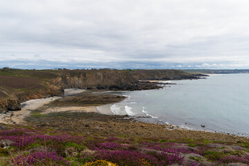 Depuis les hauteurs, vue sur les falaises et les sillons rocheux à marée basse, sous un ciel...